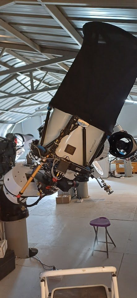 Large covered telescope inside professional observatory building